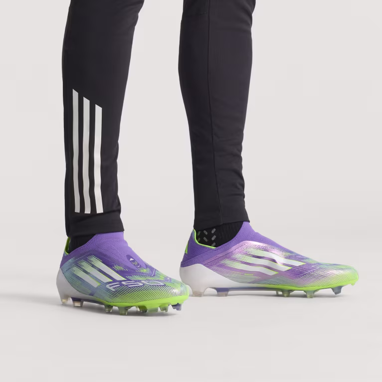 Adidas F50 Elite Laceless FG soccer cleats – purple and volt design on feet, side view